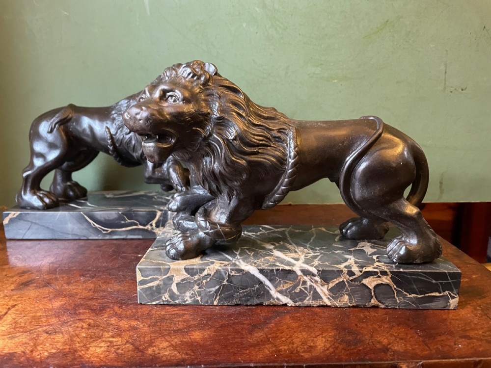 Pair of C19th French cast-iron lions with a bronze patination, mounted on portoro marble plinth bases . View III