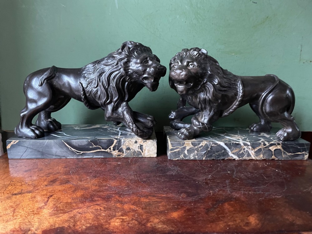 Pair of C19th French cast-iron lions with a bronze patination, mounted on portoro marble plinth bases . View V