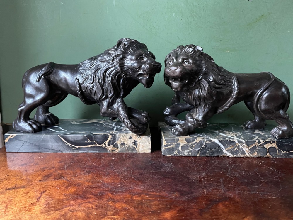 Pair of C19th French cast-iron lions with a bronze patination, mounted on portoro marble plinth bases . View VI