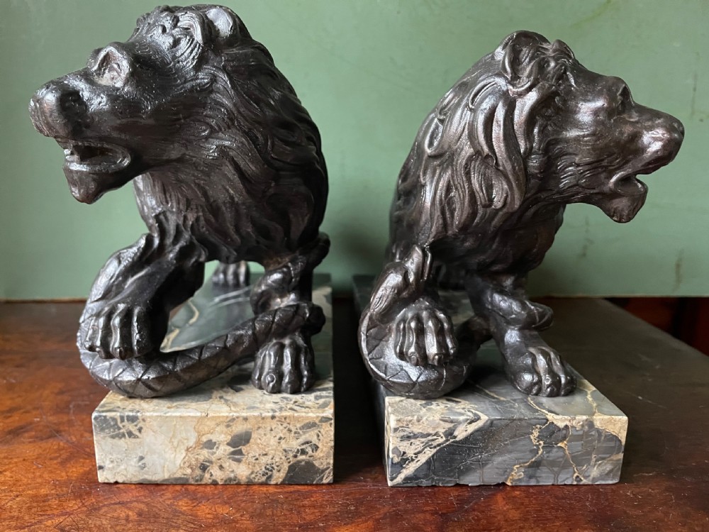 Pair of C19th French cast-iron lions with a bronze patination, mounted on portoro marble plinth bases . View VIII