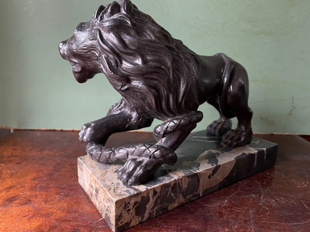 Pair of C19th French cast-iron lions with a bronze patination, mounted on portoro marble plinth bases . View X