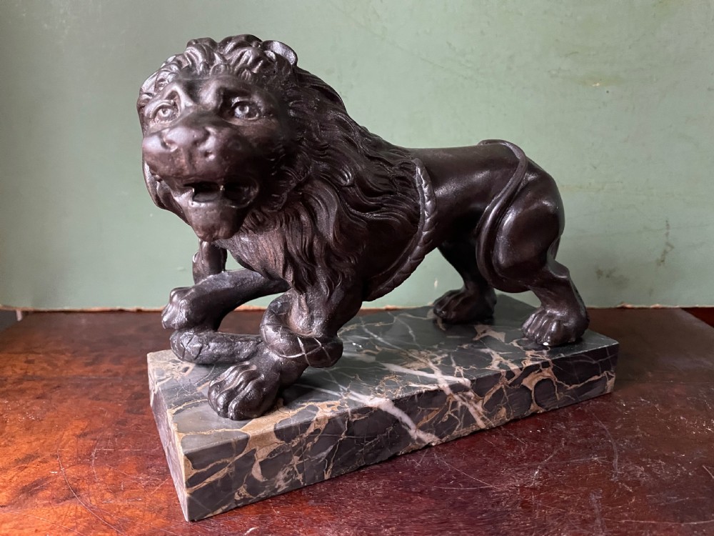 Pair of C19th French cast-iron lions with a bronze patination, mounted on portoro marble plinth bases . View XIV