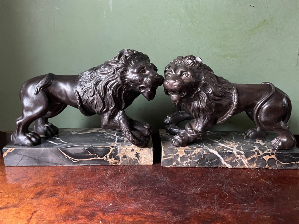 Pair of C19th French cast-iron lions with a bronze patination, mounted on portoro marble plinth bases . View XVIII