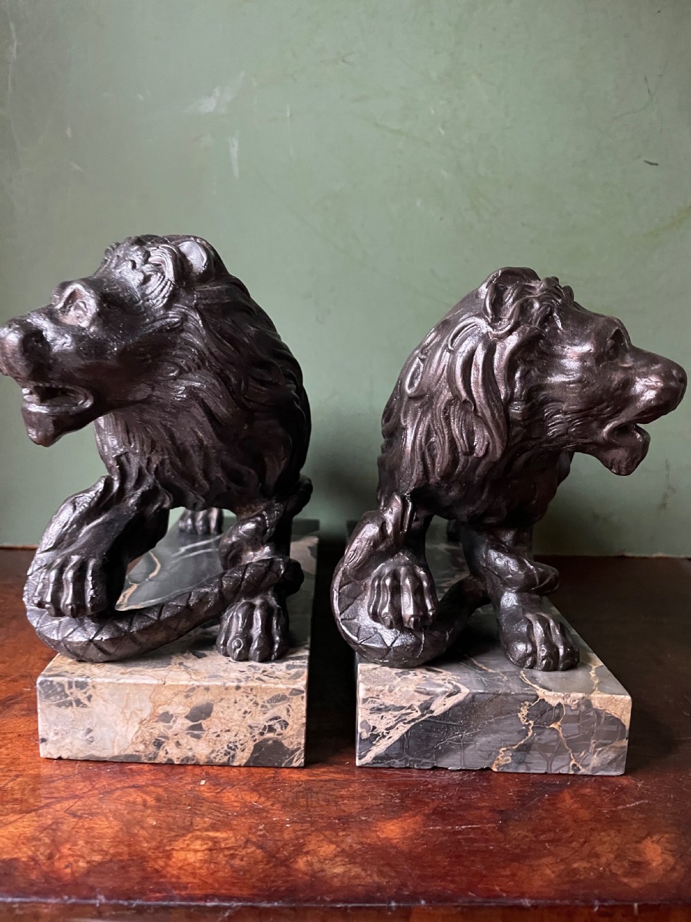 Pair of C19th French cast-iron lions with a bronze patination, mounted on portoro marble plinth bases . View XXI