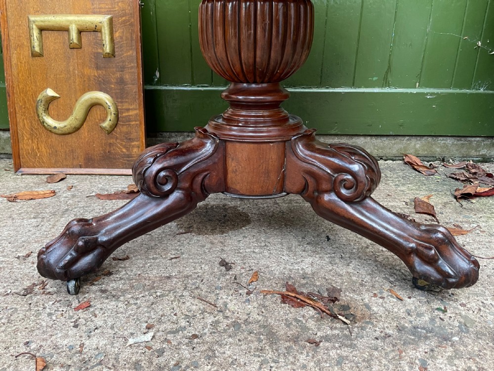 An early nineteenth-century French Charles X mahogany gueridon table featuring a circular grey marble top set upon a fluted pedestal stem and scrolled tripod feet. View V