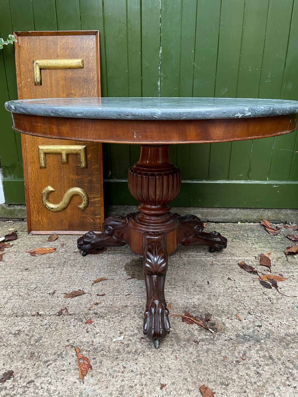 An early nineteenth-century French Charles X mahogany gueridon table featuring a circular grey marble top set upon a fluted pedestal stem and scrolled tripod feet. View VI
