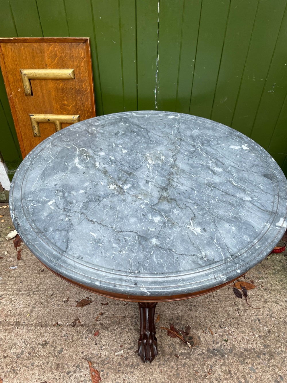 An early nineteenth-century French Charles X mahogany gueridon table featuring a circular grey marble top set upon a fluted pedestal stem and scrolled tripod feet. View VII
