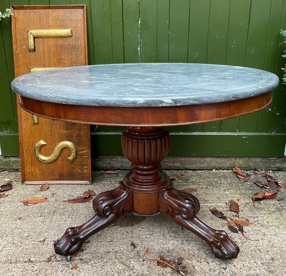 An early nineteenth-century French Charles X mahogany gueridon table featuring a circular grey marble top set upon a fluted pedestal stem and scrolled tripod feet. View XXIII