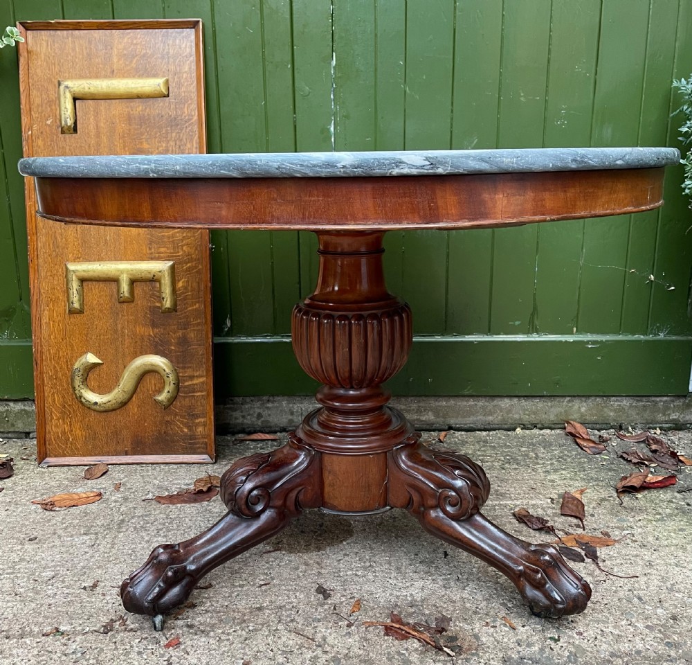 An early nineteenth-century French Charles X mahogany gueridon table featuring a circular grey marble top set upon a fluted pedestal stem and scrolled tripod feet. View XXIV