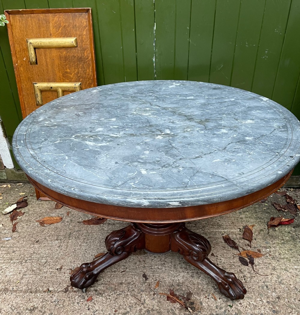 An early nineteenth-century French Charles X mahogany gueridon table featuring a circular grey marble top set upon a fluted pedestal stem and scrolled tripod feet. View XXV