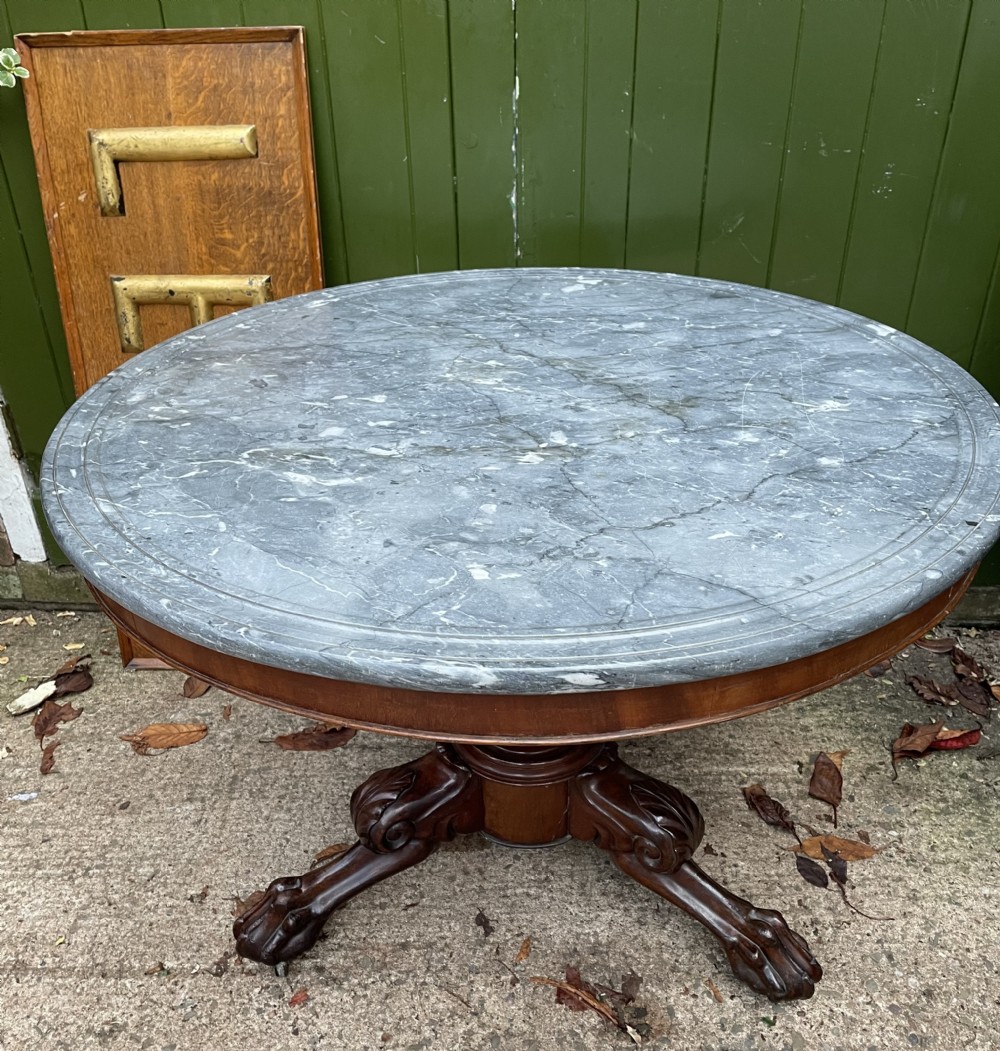 An early nineteenth-century French Charles X mahogany gueridon table featuring a circular grey marble top set upon a fluted pedestal stem and scrolled tripod feet. View II