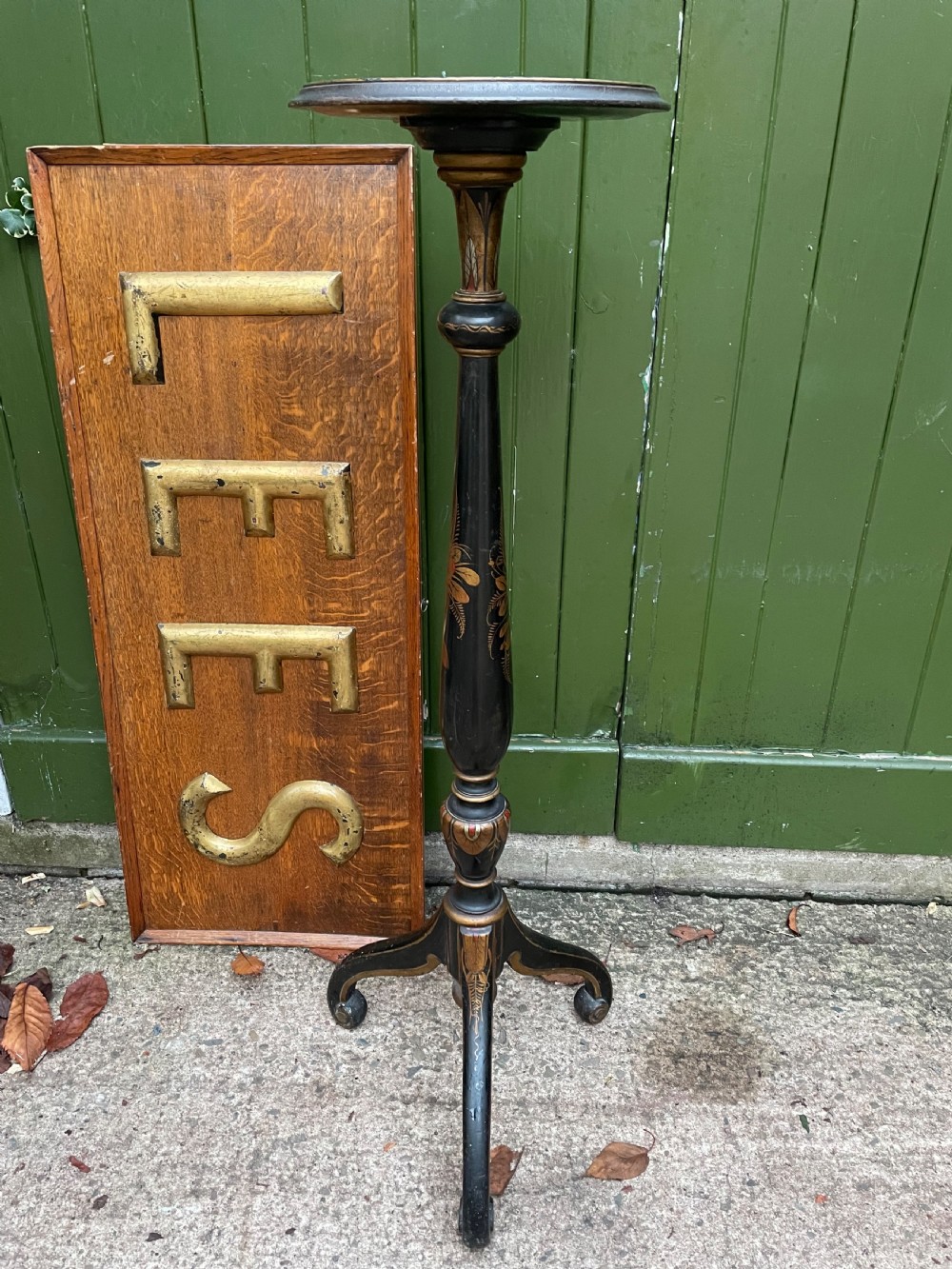 A black lacquered wooden torchere stand featuring gilt floral chinoiserie decoration, a turned central shaft, and a tripod base. View II