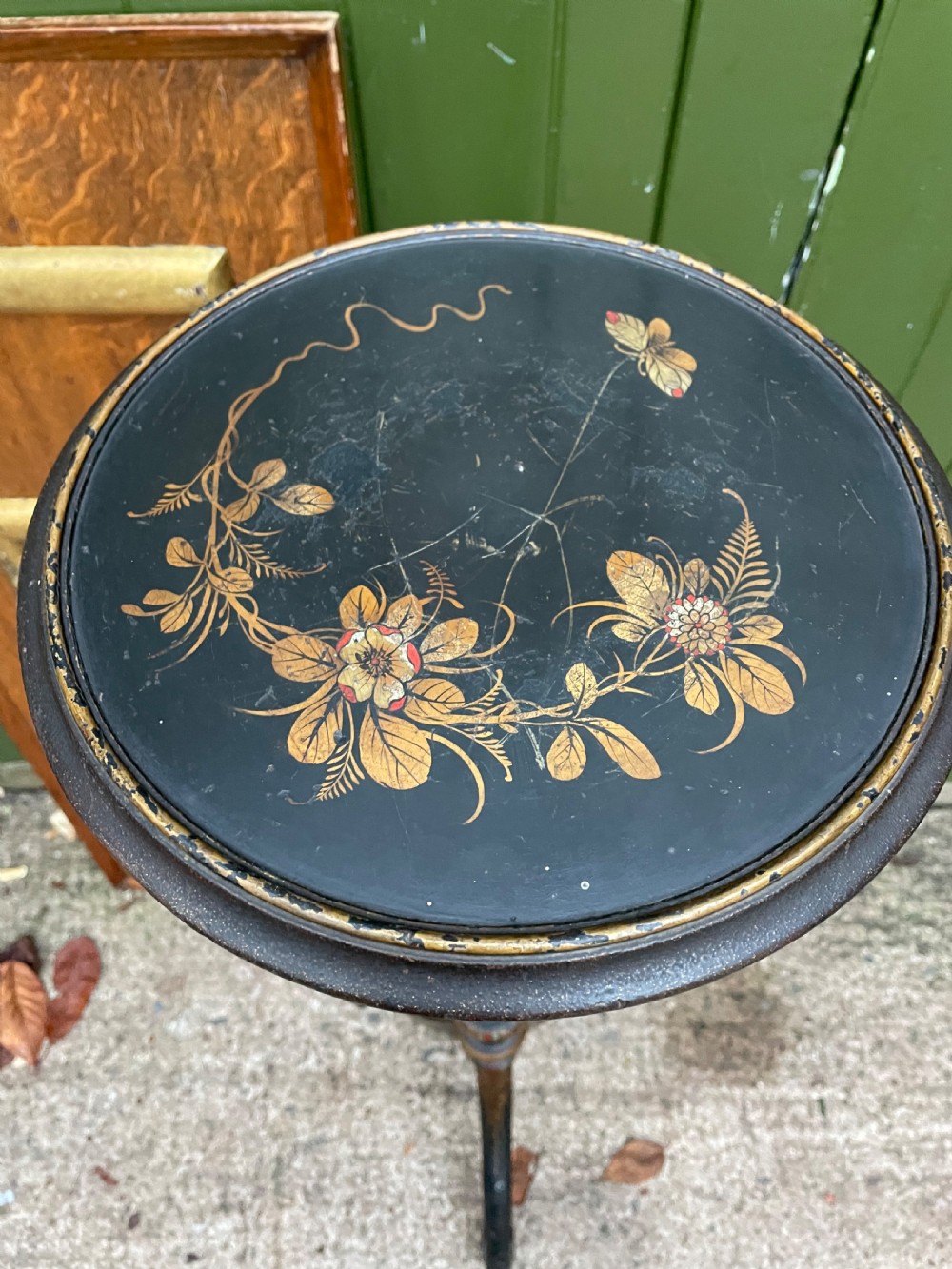 A black lacquered wooden torchere stand featuring gilt floral chinoiserie decoration, a turned central shaft, and a tripod base. View III