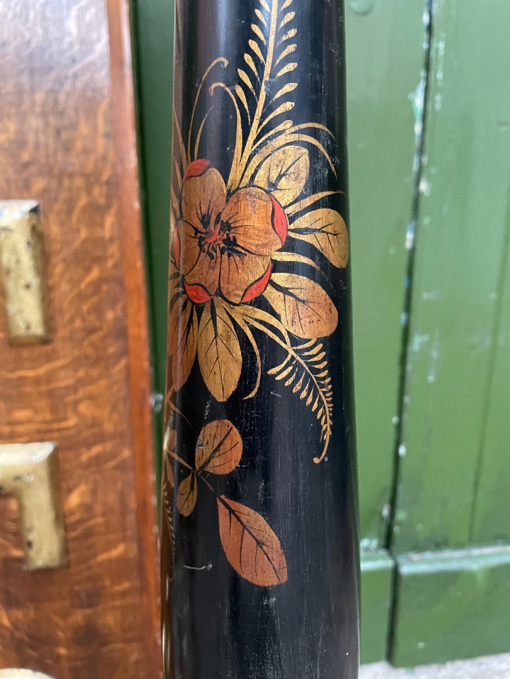 A black lacquered wooden torchere stand featuring gilt floral chinoiserie decoration, a turned central shaft, and a tripod base. View IV