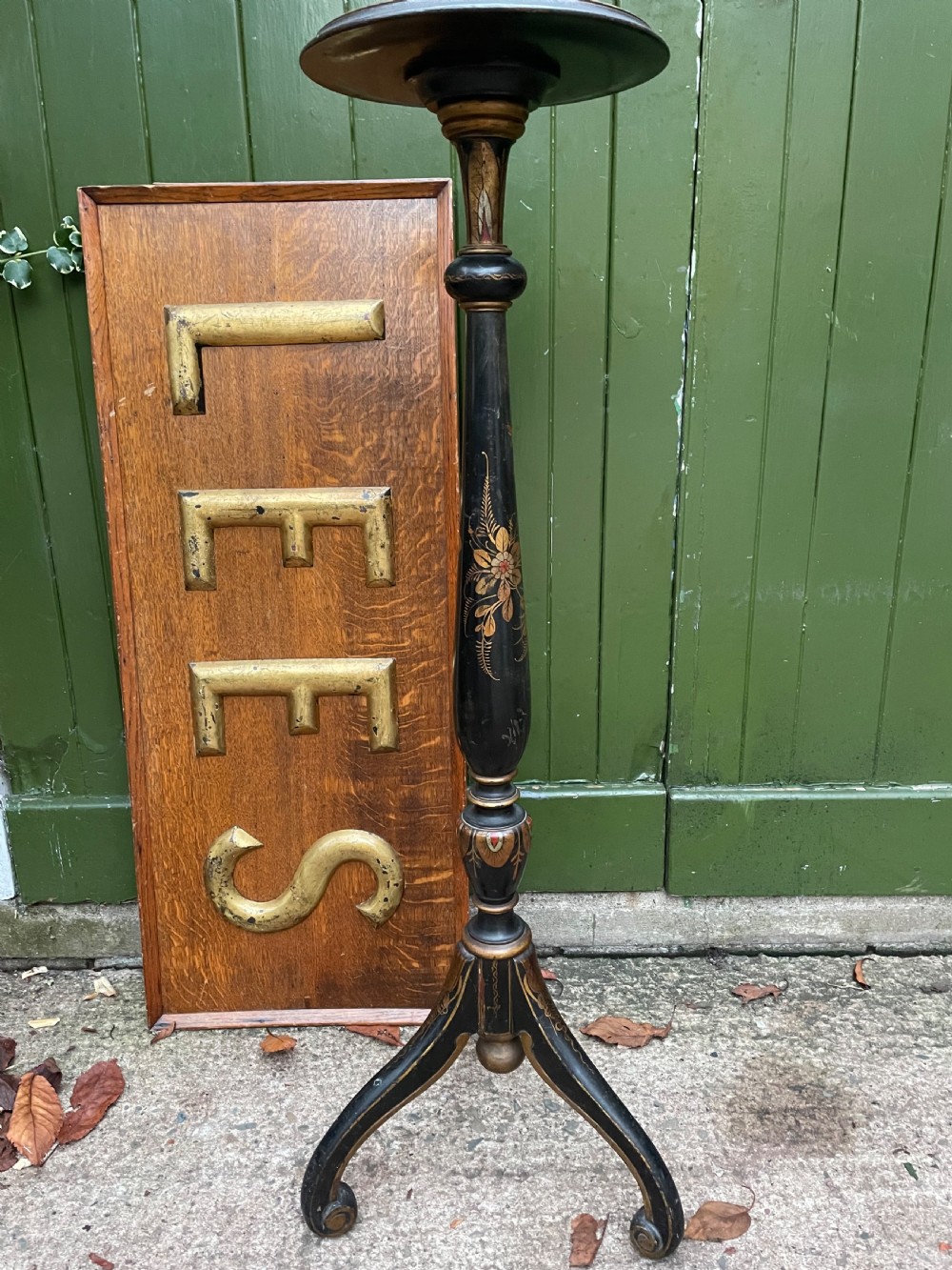 A black lacquered wooden torchere stand featuring gilt floral chinoiserie decoration, a turned central shaft, and a tripod base. View VI