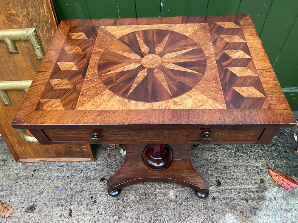 A nineteenth-century rectangular rosewood side table featuring a starburst specimen wood inlaid top set on a pedestal base with a quadform platform. View III
