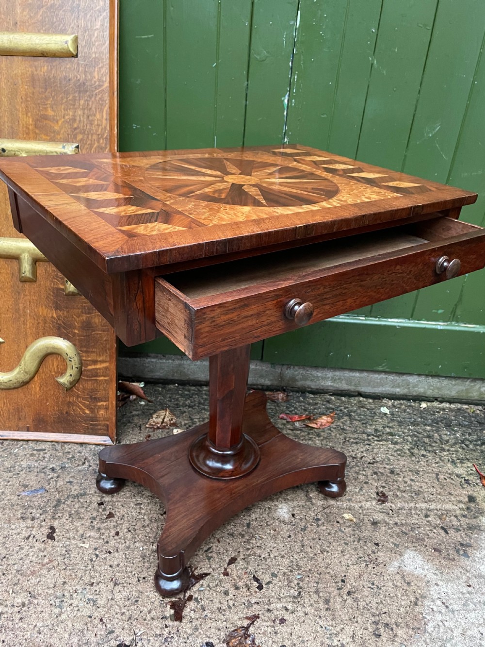A nineteenth-century rectangular rosewood side table featuring a starburst specimen wood inlaid top set on a pedestal base with a quadform platform. View XI