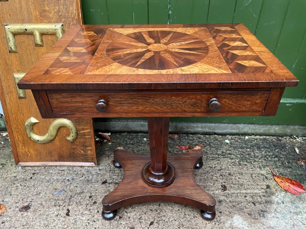 A nineteenth-century rectangular rosewood side table featuring a starburst specimen wood inlaid top set on a pedestal base with a quadform platform. View XII