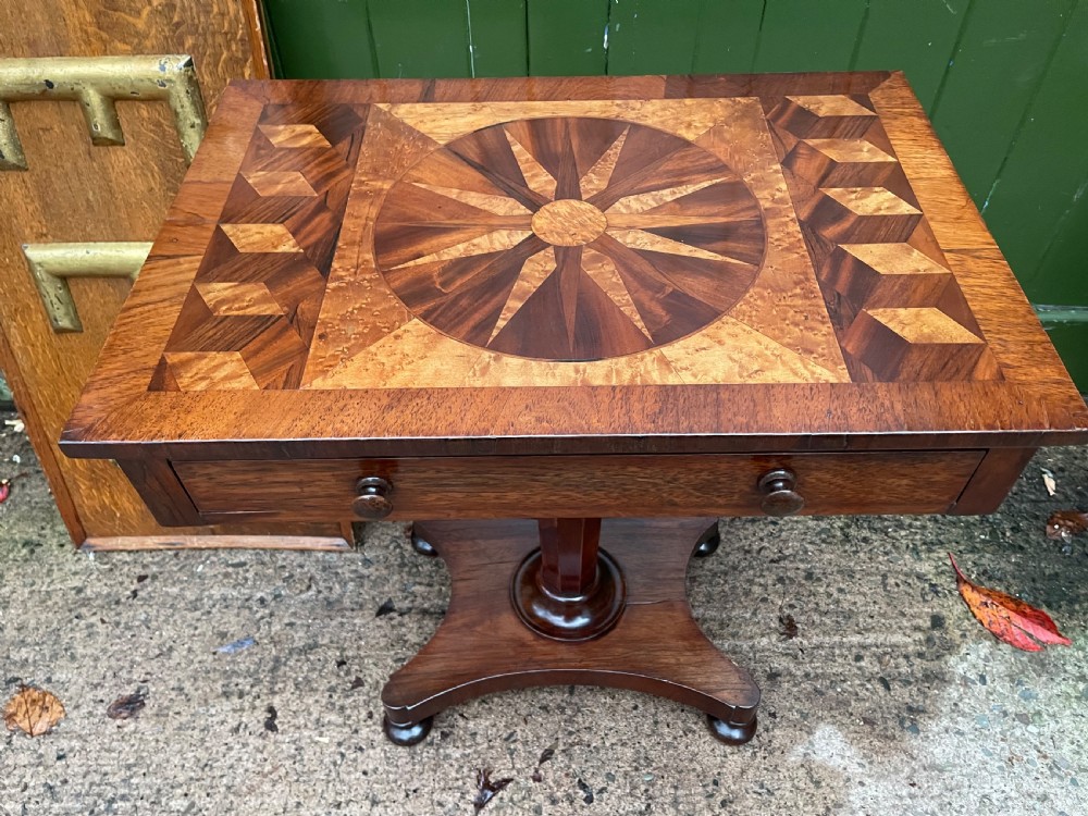 A nineteenth-century rectangular rosewood side table featuring a starburst specimen wood inlaid top set on a pedestal base with a quadform platform. View XIV