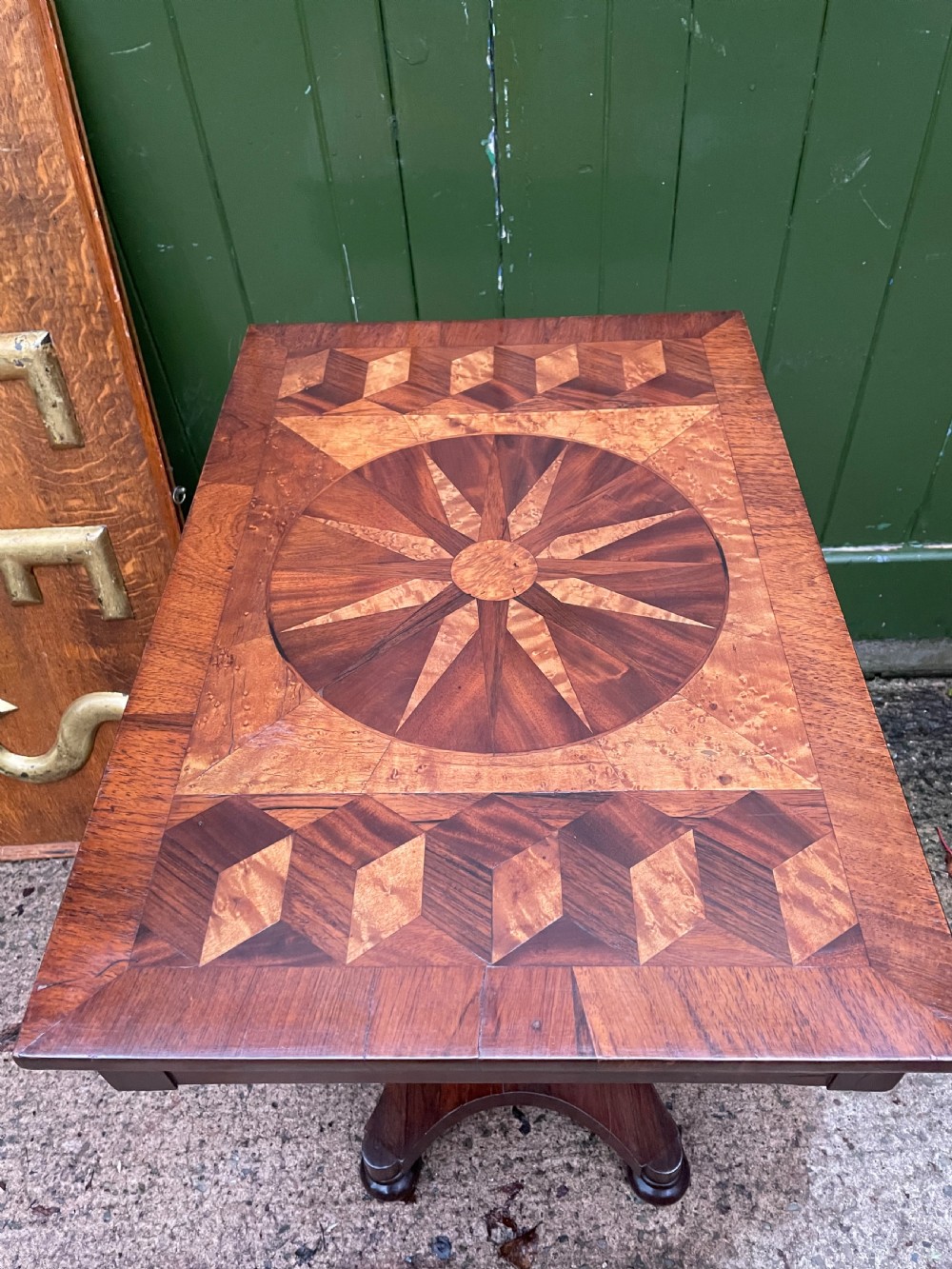 A nineteenth-century rectangular rosewood side table featuring a starburst specimen wood inlaid top set on a pedestal base with a quadform platform. View XVI