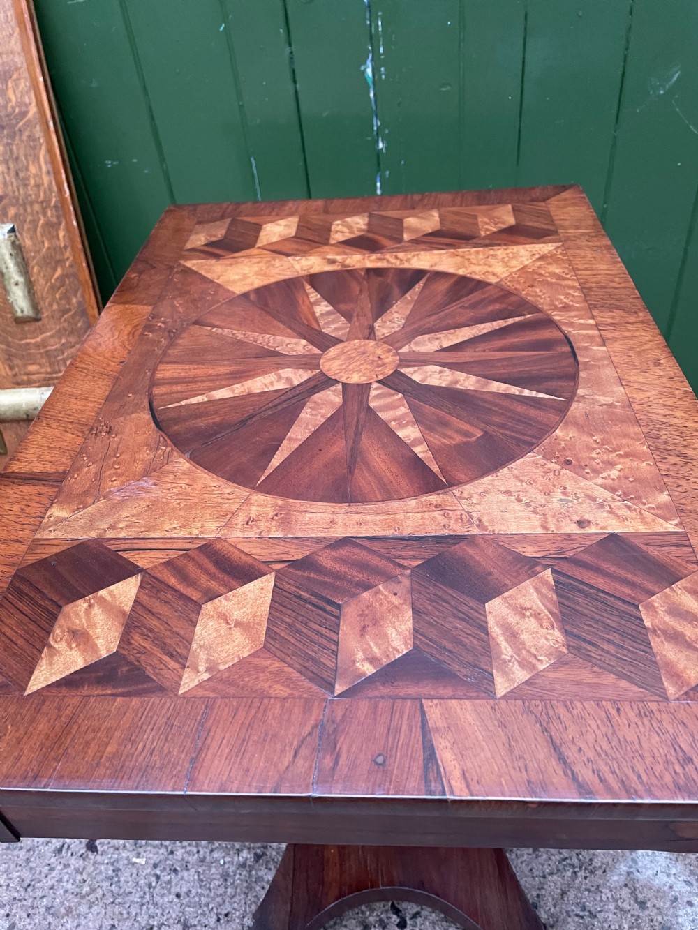 A nineteenth-century rectangular rosewood side table featuring a starburst specimen wood inlaid top set on a pedestal base with a quadform platform. View XVII