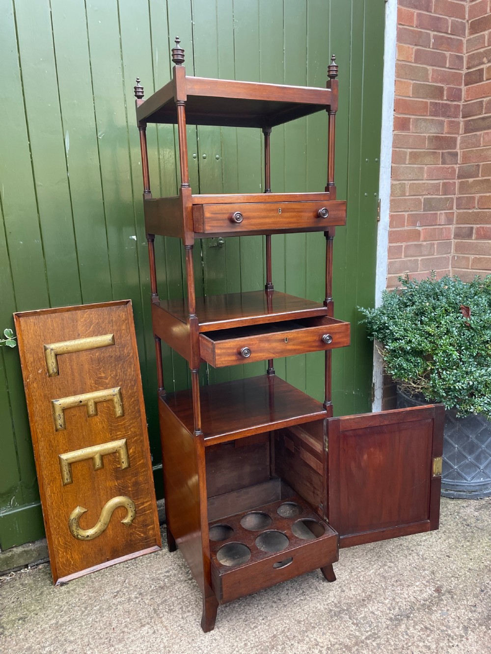A tall late eighteenth-century George III mahogany etagere featuring open shelves, turned column supports, two drawers, and a lower enclosed cupboard. View IX