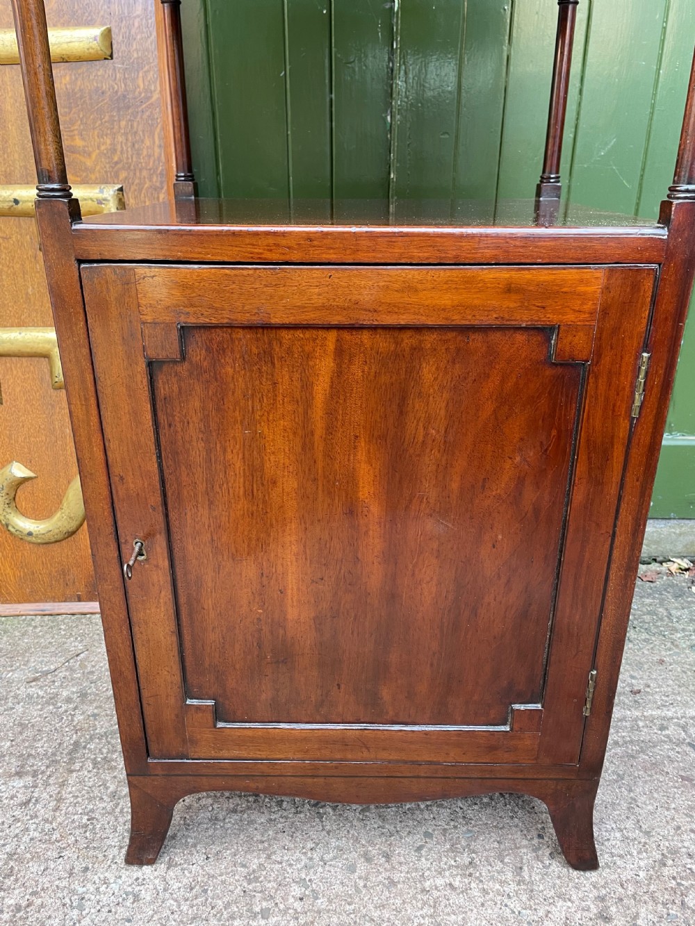 A tall late eighteenth-century George III mahogany etagere featuring open shelves, turned column supports, two drawers, and a lower enclosed cupboard. View X