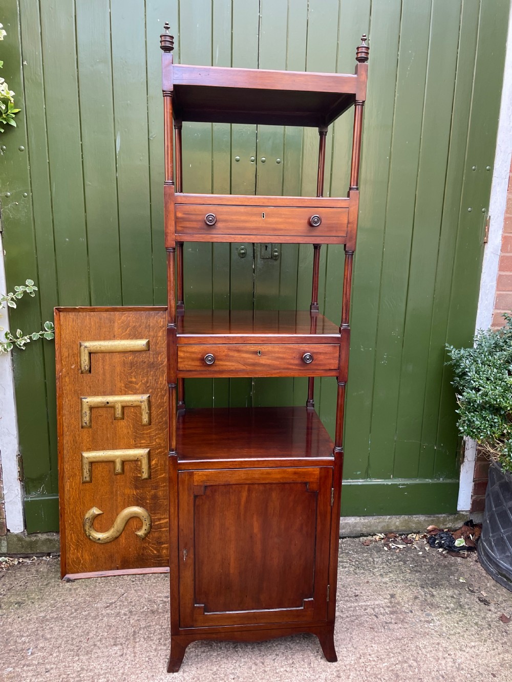 A tall late eighteenth-century George III mahogany etagere featuring open shelves, turned column supports, two drawers, and a lower enclosed cupboard. View XI