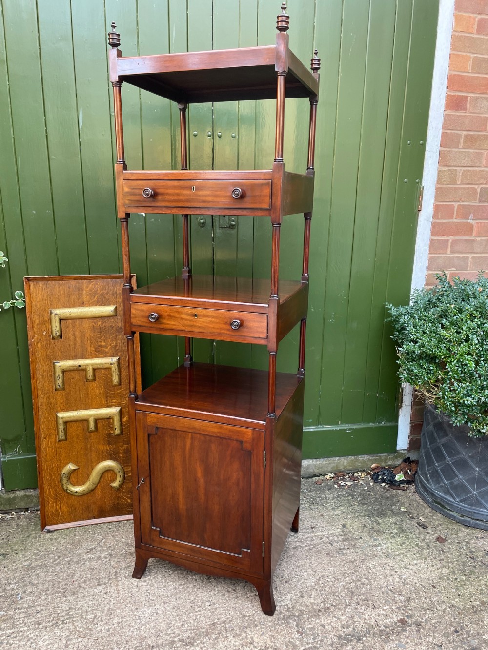 A tall late eighteenth-century George III mahogany etagere featuring open shelves, turned column supports, two drawers, and a lower enclosed cupboard. View XIII