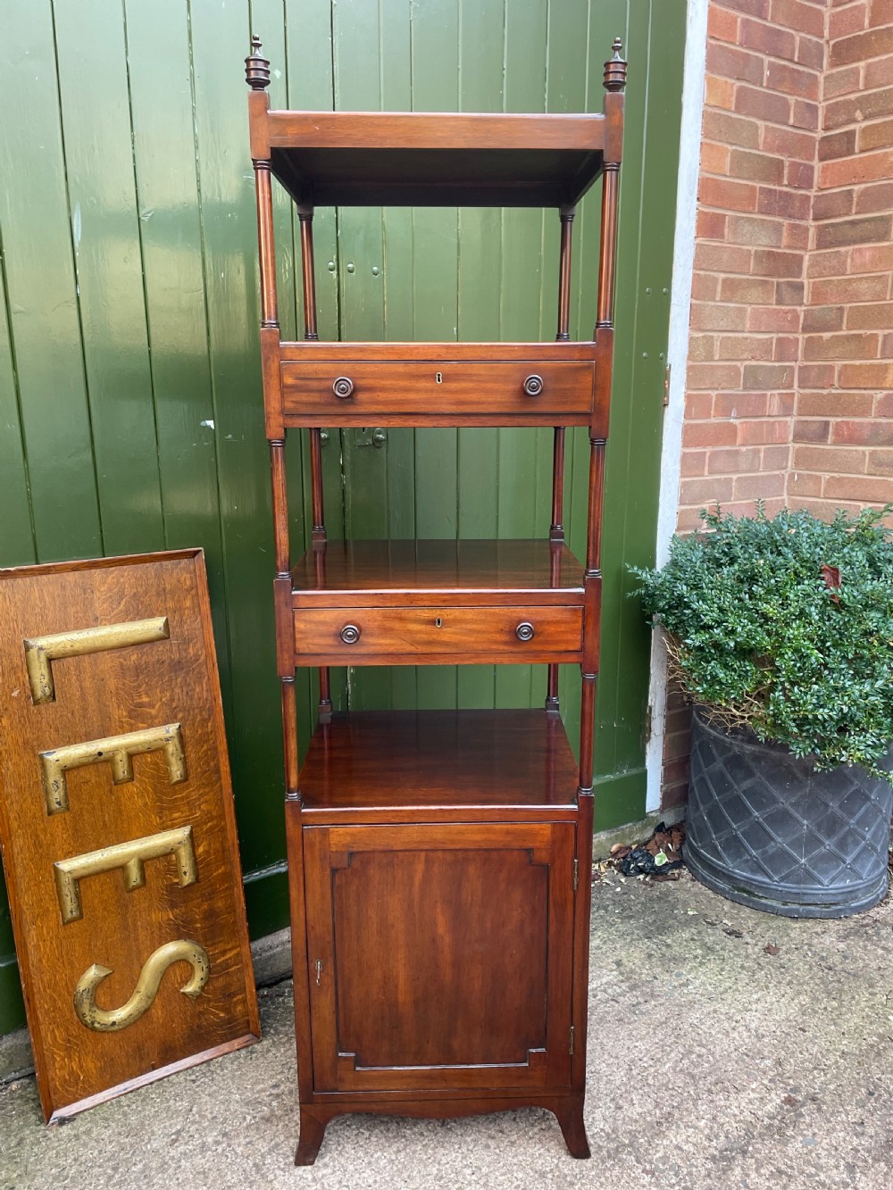 A tall late eighteenth-century George III mahogany etagere featuring open shelves, turned column supports, two drawers, and a lower enclosed cupboard. View XIV