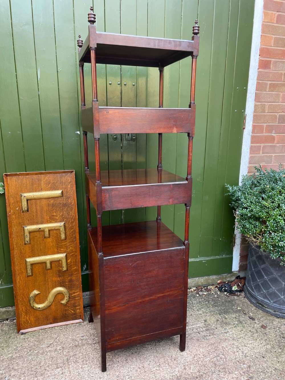 A tall late eighteenth-century George III mahogany etagere featuring open shelves, turned column supports, two drawers, and a lower enclosed cupboard. View XVIII