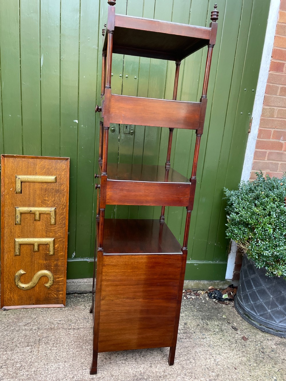 A tall late eighteenth-century George III mahogany etagere featuring open shelves, turned column supports, two drawers, and a lower enclosed cupboard. View XIX