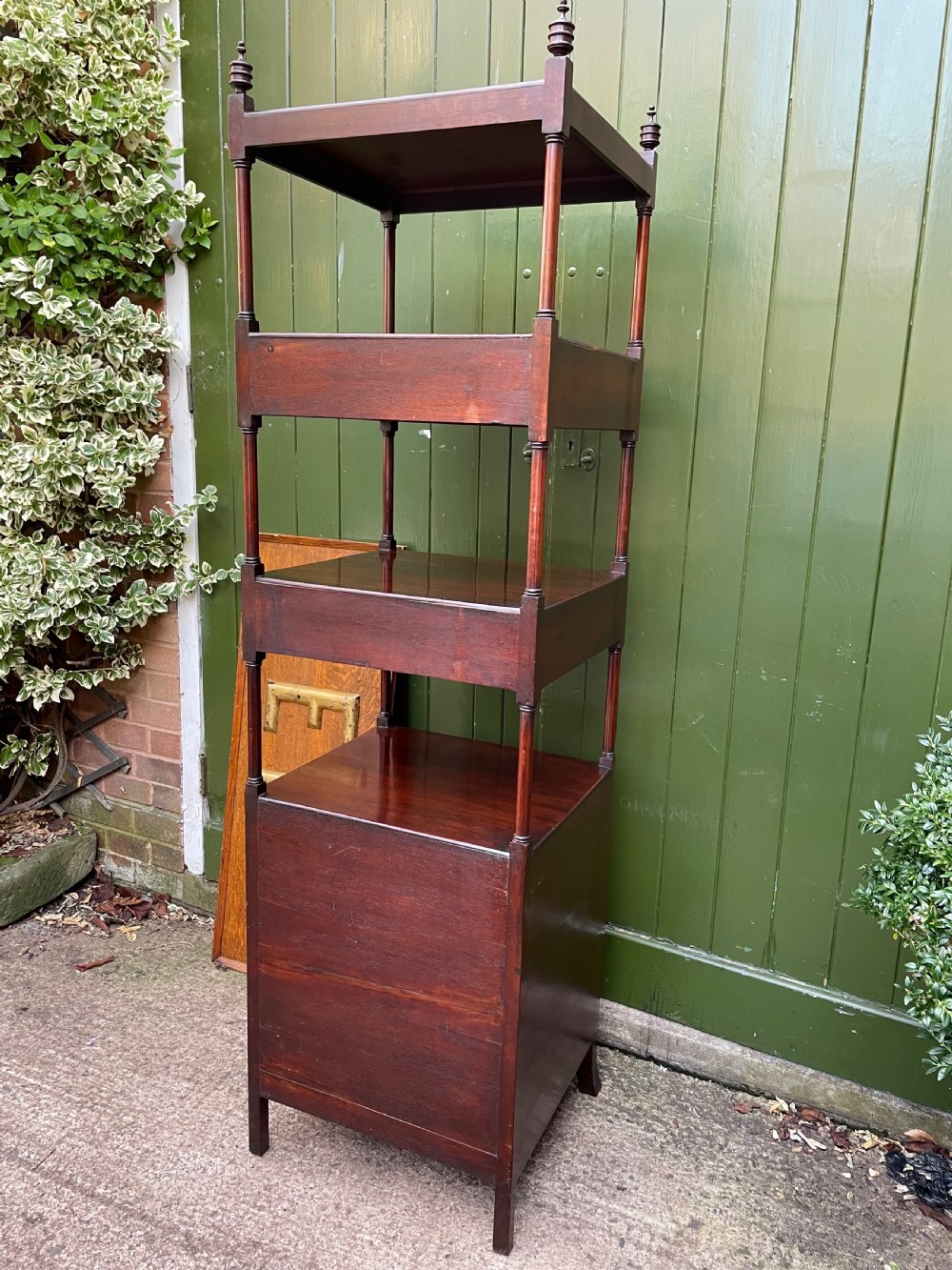 A tall late eighteenth-century George III mahogany etagere featuring open shelves, turned column supports, two drawers, and a lower enclosed cupboard. View XX