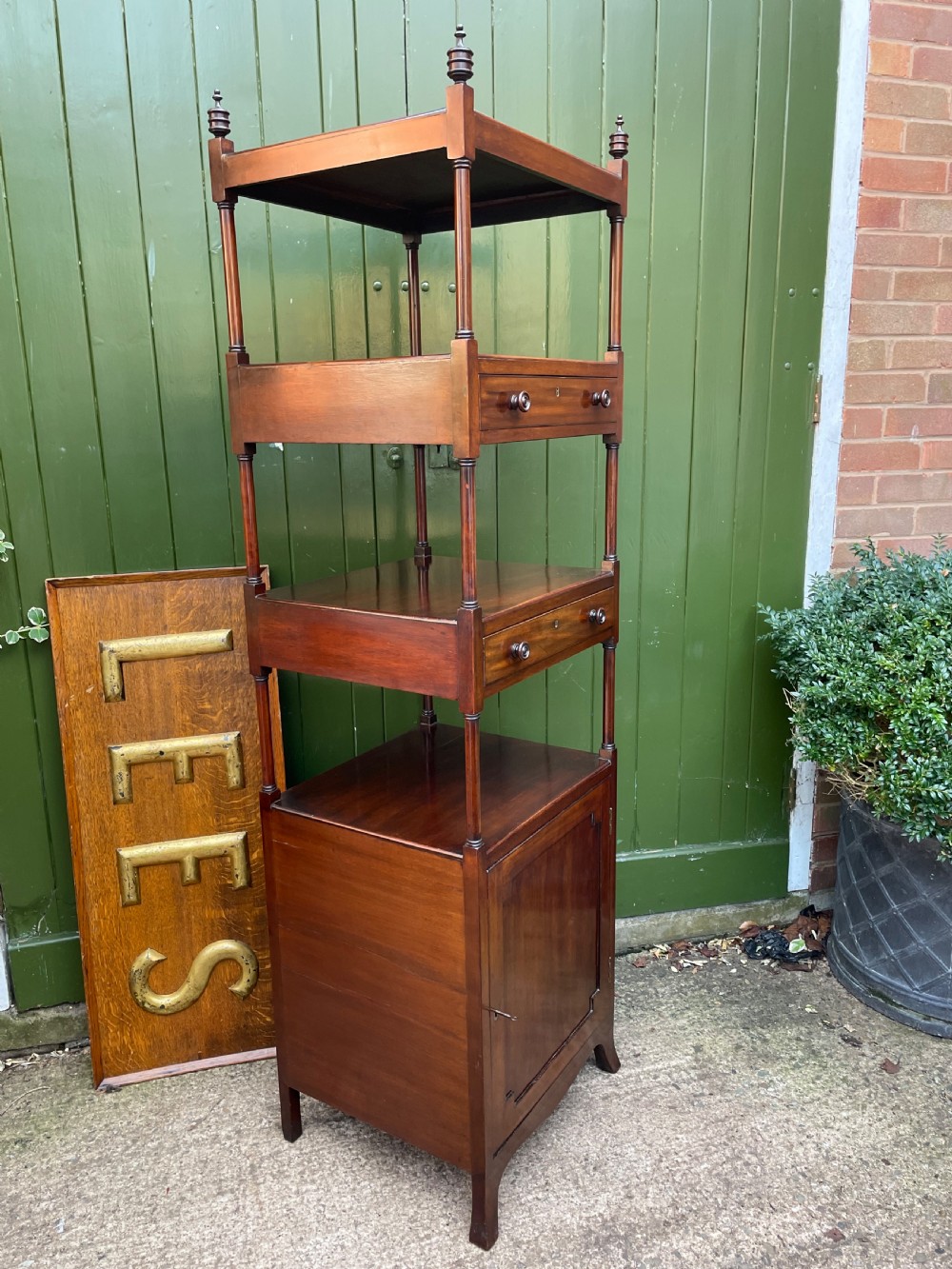 A tall late eighteenth-century George III mahogany etagere featuring open shelves, turned column supports, two drawers, and a lower enclosed cupboard. View XXI