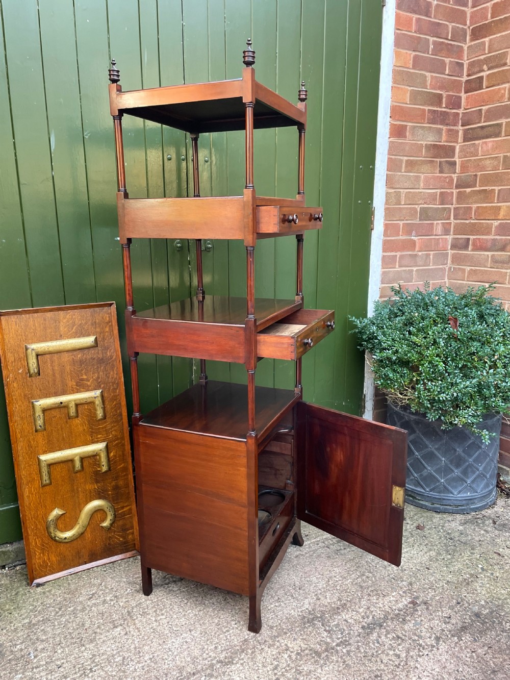 A tall late eighteenth-century George III mahogany etagere featuring open shelves, turned column supports, two drawers, and a lower enclosed cupboard. View XXIV