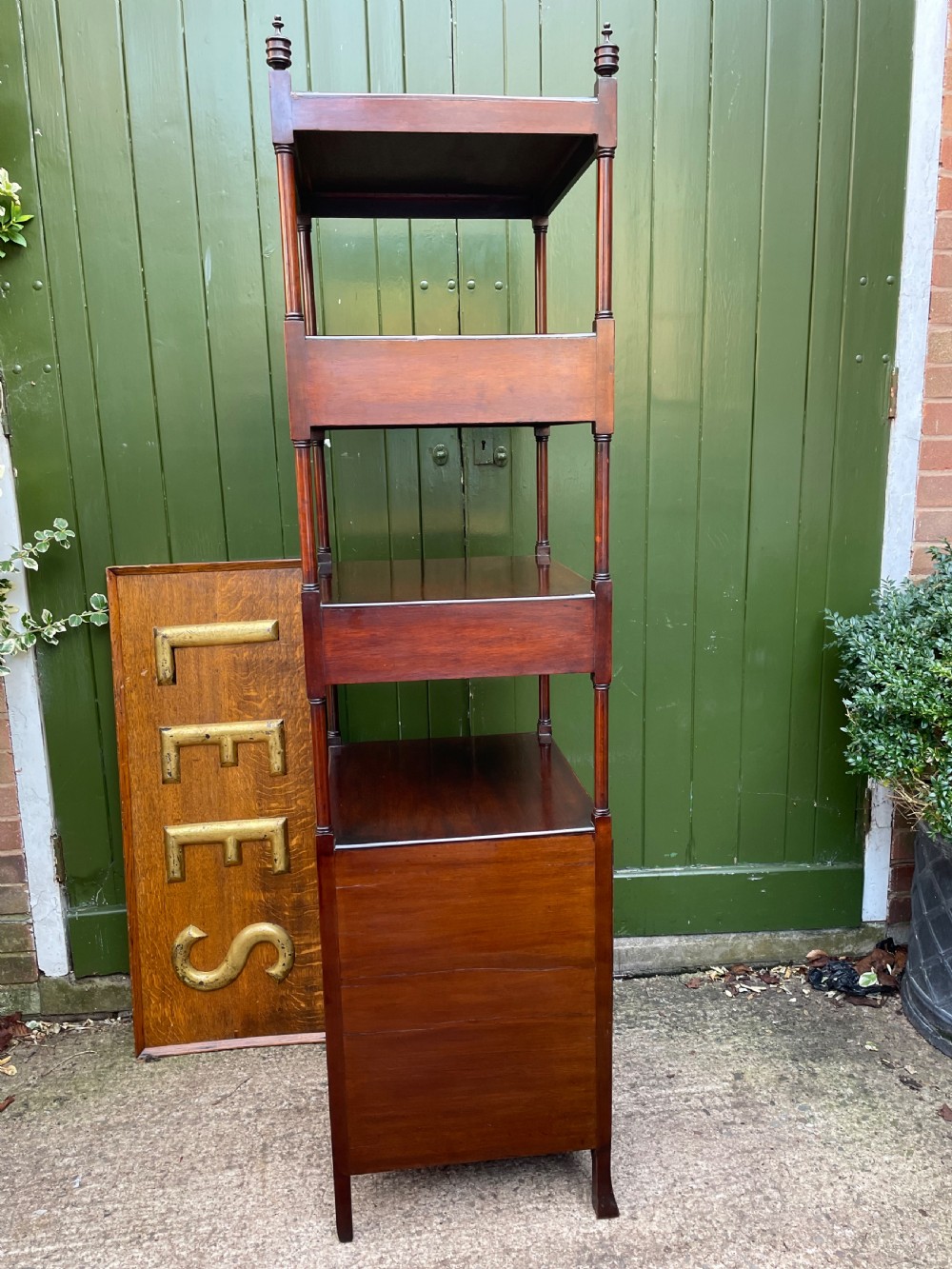 A tall late eighteenth-century George III mahogany etagere featuring open shelves, turned column supports, two drawers, and a lower enclosed cupboard. View XXV