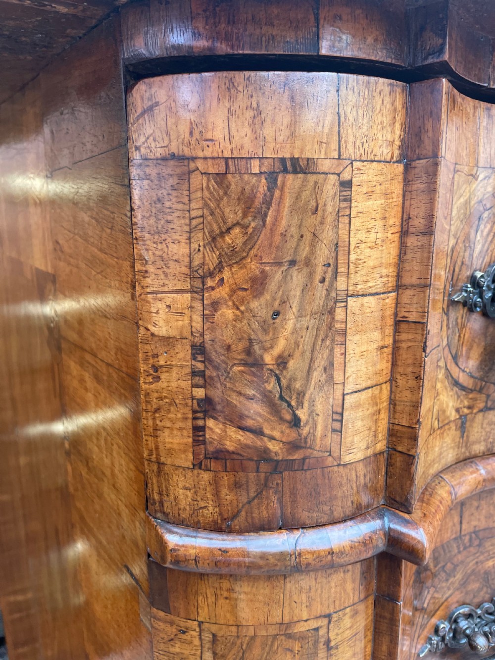 A mid-18th-century German Baroque walnut commode featuring a shaped serpentine front, four long drawers with figured wood veneers, and ornate cast brass handles. View VII