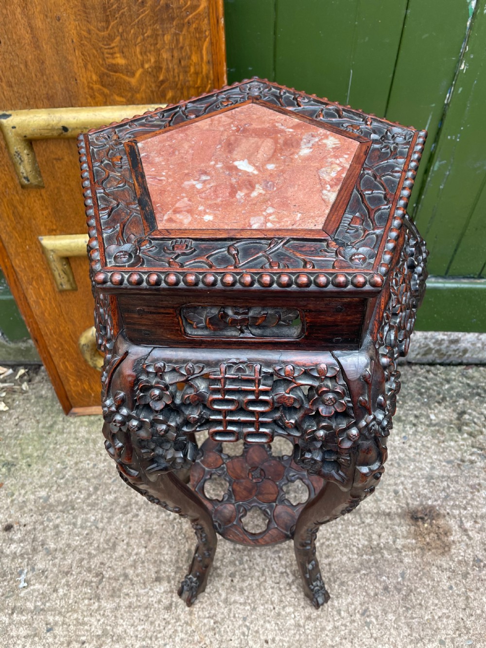 A late nineteenth-century Chinese carved dark hardwood plant stand featuring intricate floral openwork aprons, slender curved legs, and a lower circular tier. View III