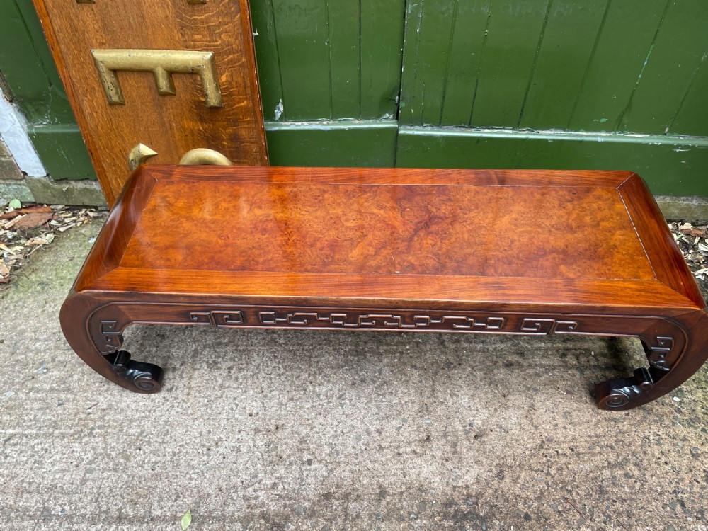 A low Chinese Qing Dynasty hardwood kang table featuring carved key-fret aprons and inward-curved scroll legs. View III