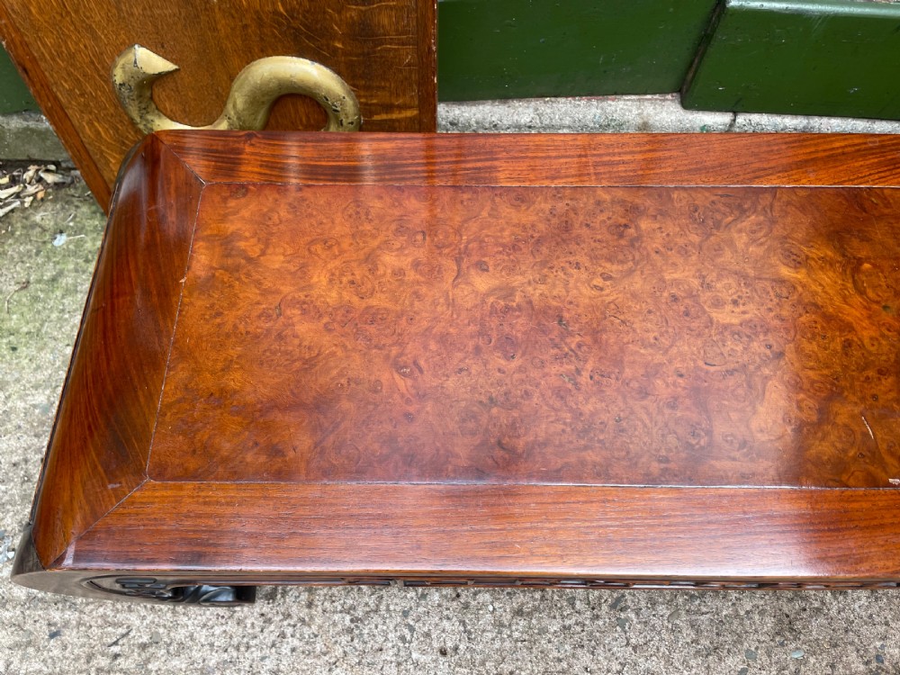 A low Chinese Qing Dynasty hardwood kang table featuring carved key-fret aprons and inward-curved scroll legs. View VI