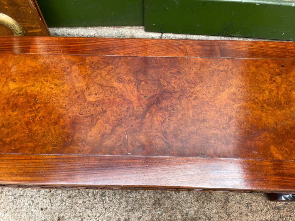 A low Chinese Qing Dynasty hardwood kang table featuring carved key-fret aprons and inward-curved scroll legs. View VII