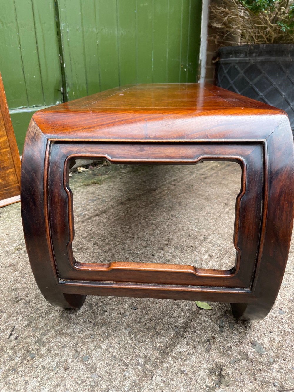 A low Chinese Qing Dynasty hardwood kang table featuring carved key-fret aprons and inward-curved scroll legs. View VIII