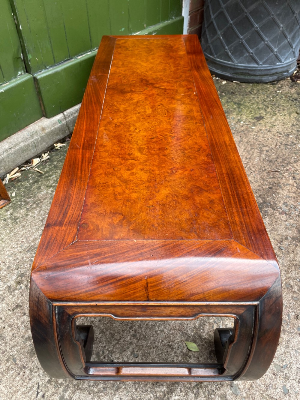 A low Chinese Qing Dynasty hardwood kang table featuring carved key-fret aprons and inward-curved scroll legs. View X