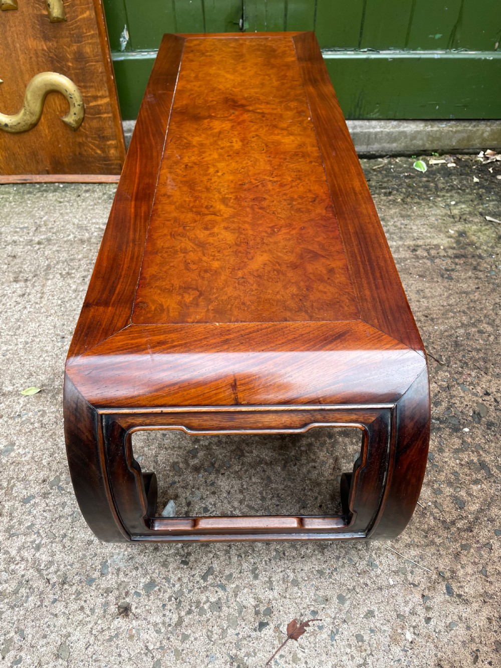 A low Chinese Qing Dynasty hardwood kang table featuring carved key-fret aprons and inward-curved scroll legs. View XI