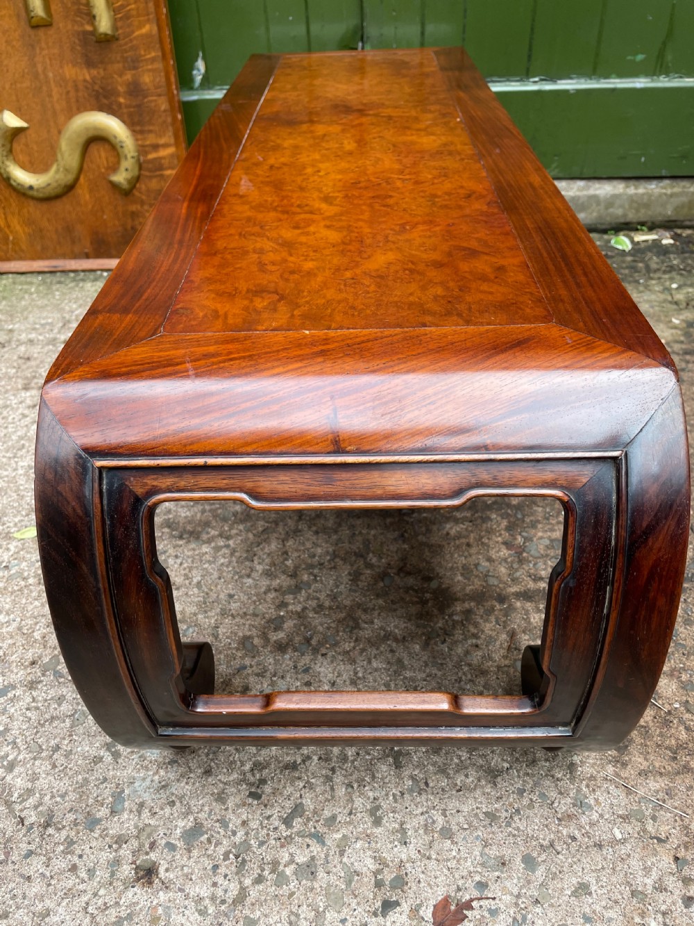 A low Chinese Qing Dynasty hardwood kang table featuring carved key-fret aprons and inward-curved scroll legs. View XII