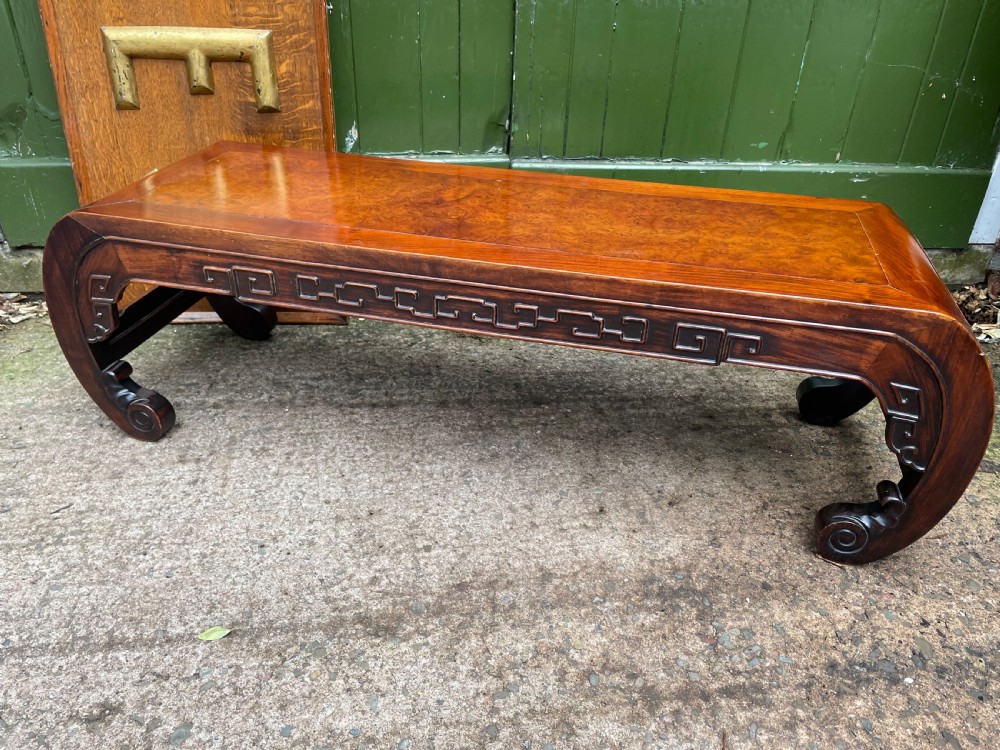A low Chinese Qing Dynasty hardwood kang table featuring carved key-fret aprons and inward-curved scroll legs. View XIV