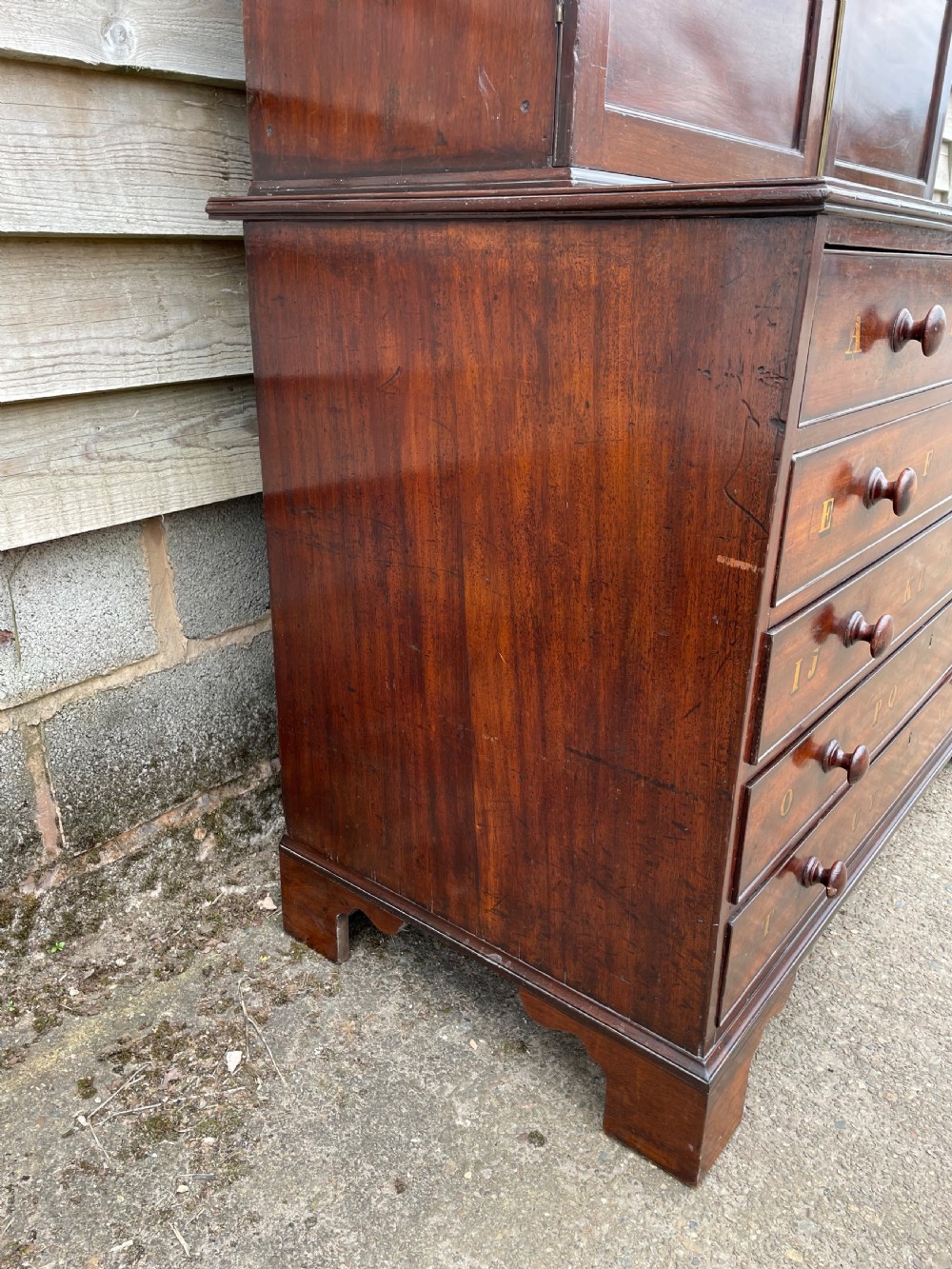 A late eighteenth-century George III mahogany estate cabinet featuring upper panel doors above drawers with gilded alphabetical lettering. View VIII