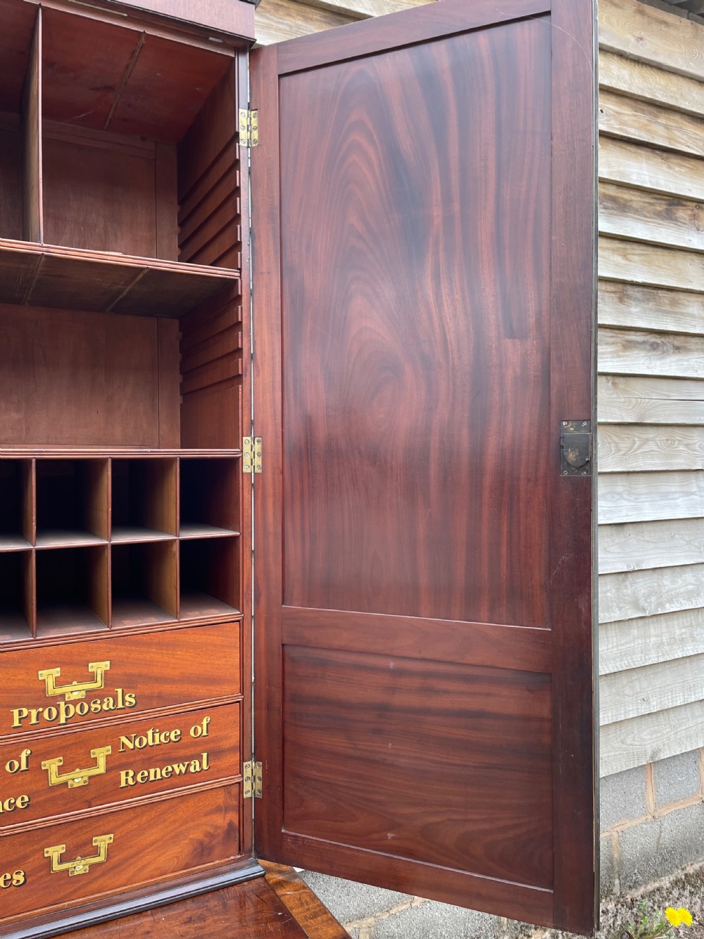 A late eighteenth-century George III mahogany estate cabinet featuring upper panel doors above drawers with gilded alphabetical lettering. View XIII