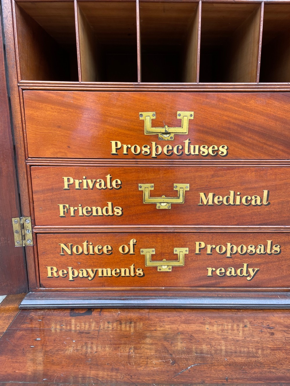 A late eighteenth-century George III mahogany estate cabinet featuring upper panel doors above drawers with gilded alphabetical lettering. View XVIII