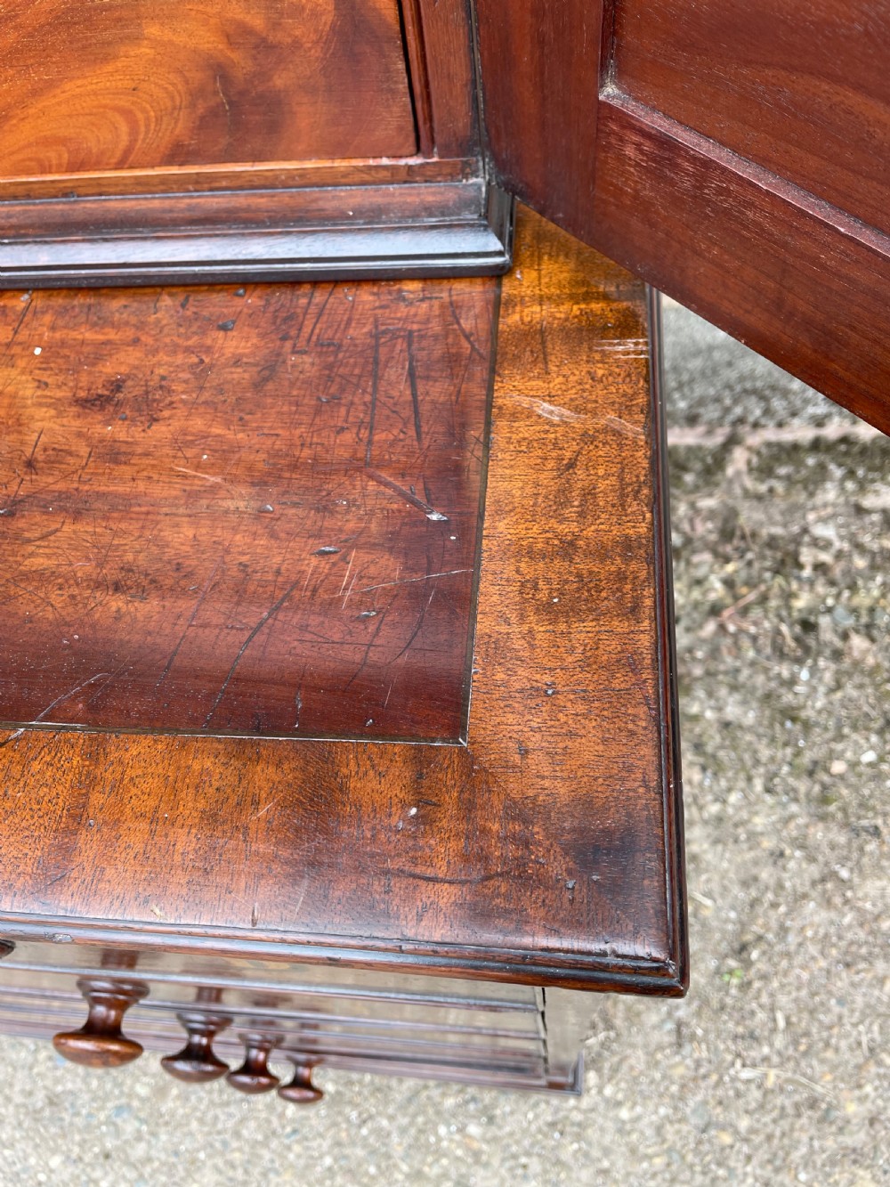 A late eighteenth-century George III mahogany estate cabinet featuring upper panel doors above drawers with gilded alphabetical lettering. View XXVI